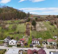 A residential plot in the village of Lietava next to Majer Street, surrounded by nature and neighboring houses.