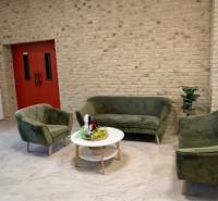 Spacious office with sofas, kitchenette, and brick wall.
