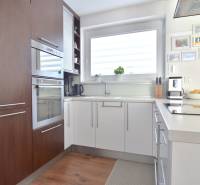 A kitchen in a 3-room apartment with a wood-patterned floor and a large window.