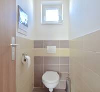 A small toilet with a window and tiles in a 3-room apartment.
