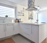 A kitchen in a 3-room apartment with Eiffel Tower decor and a wooden decor floor.