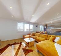 Living room with wood-patterned flooring and an orange sofa in a family house.