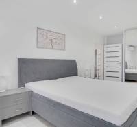 A bright bedroom with a large bed and a wardrobe in a 2-room apartment.