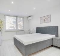 Bedroom in a 2-room apartment with a large bed and decoration in muted colors.