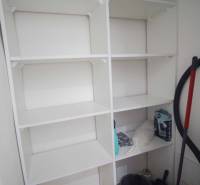 Storage space with white shelves in a 2-room apartment.