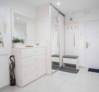 Entrance hall with white furniture and a mirror in a 2-room apartment.