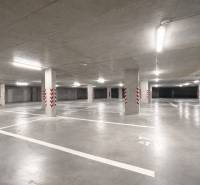 Spacious garages with marked parking spaces, bright lighting, concrete pillars.