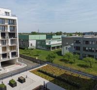A view of residential buildings and greenery on Eduarda Wenzla in Bratislava-Rača, garages on the right.