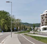 On Eduard Wenzl Street, there are trees, a building, and garages along the road.