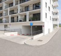 Residential building with parking entrance in Bratislava-Rača on Eduarda Wenzla Street.