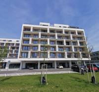 Apartment building on Eduarda Wenzla Street with parking and garages in the foreground.