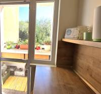 A bedroom with a desk and access to a balcony in a 3-room apartment.