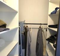 A wardrobe with built-in shelves and a wooden decor floor in a 3-room apartment.