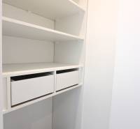 White wardrobe with drawers and shelves in a 3-room apartment.