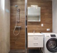 A bathroom in a 3-room apartment with wooden decor and a washing machine.
