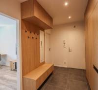 Entrance hall of a 3-room apartment with a tiled floor and wooden decor.