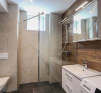 A bathroom in a 3-room apartment with modern sanitary fixtures and a wooden decor floor.
