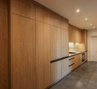 A kitchen in a 3-room apartment with a wood-patterned floor and built-in appliances.