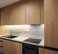 A kitchen in a 3-room apartment with a wooden decor kitchen unit and built-in appliances.