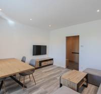 Living room in a three-room apartment with a wooden decor floor and wooden furniture.