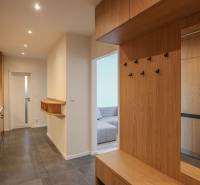 A hallway with a wooden decor floor and wardrobe closets in a 3-room apartment.