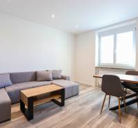 Living room with a corner sofa, dining table, and wooden decor flooring.