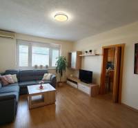 A bright living room with a blue sofa in a three-room apartment, wooden decor flooring.