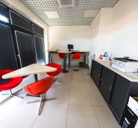Offices with red chairs and a computer, tiled floor.