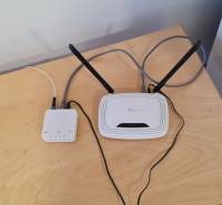 A table with a network device and a router in a studio apartment, floor with wooden decor.