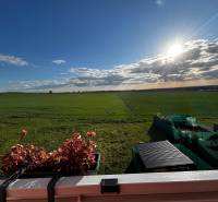 A view of the vast green landscape and a balcony with flowers in Gbelá.