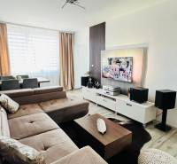 Living room with a corner sofa, TV stand, and wooden decor flooring.