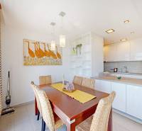Dining area with a wooden table and decorative art in a 2-room apartment.