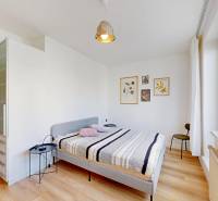 Bedroom in a 2-room apartment with a bed, nightstand, and wooden decor flooring.