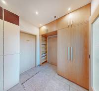 Built-in wardrobes and tiled floor in a 2-room apartment with light furniture.