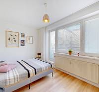 A bright bedroom in a two-room apartment with decorations on the white wall.