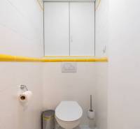 Bathroom with white tiles and yellow details in the Holiday Apartment.