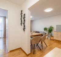 Interior of a holiday apartment with a wooden decor floor, dining area, and bedroom.