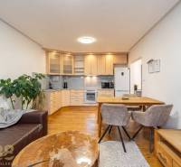 Living room with a kitchenette in a holiday apartment and a floor with a wooden decor.