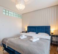 Bedroom in a holiday apartment with a double bed and wooden decor flooring.