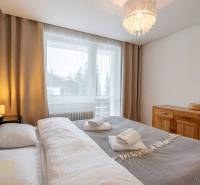 Bedroom in a holiday apartment with a double bed and a dresser, window with a view.