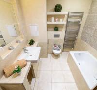 Bathroom in a 2-room apartment with a bathtub, sink, mirror, and towel rack.