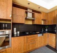 A kitchen in a 2-room apartment with a wooden decor and stainless steel appliances.