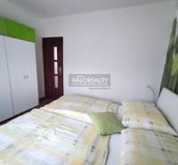 A bedroom in a 4-room apartment with a bed, a wardrobe, and a decorative wall with a flower.