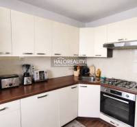 A kitchen in a 4-room apartment with white cabinets and a wood-patterned floor.