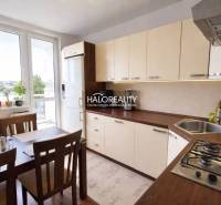 A kitchen in a 4-room apartment with a large window, a dining table, and light furniture.