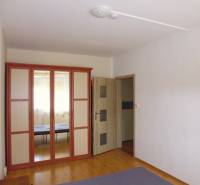 Interior of a 2-room apartment with a large mirrored wardrobe and a floor with a wooden decor.