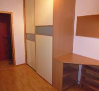 A workspace with furniture and flooring featuring a wooden decor in a 2-room apartment.