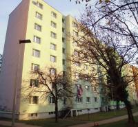 Apartment building in Prešov with a sidewalk and trees.
