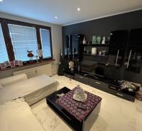 Living room in a two-room apartment with modern furniture and tiled flooring.