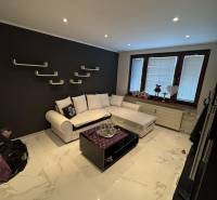 Living room in a two-room apartment with a dark wall and modern furnishings.